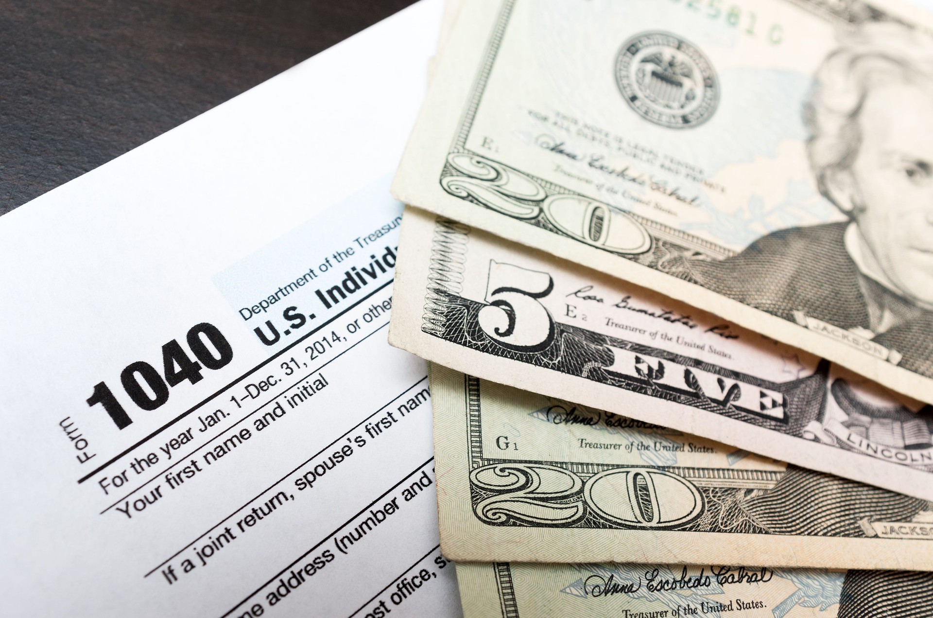 1040 Individual tax return form close up and dollar bils